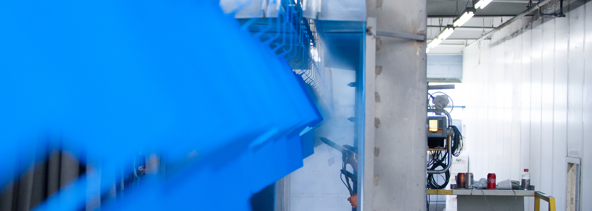 metal boxes being powder coated with blue powder coating