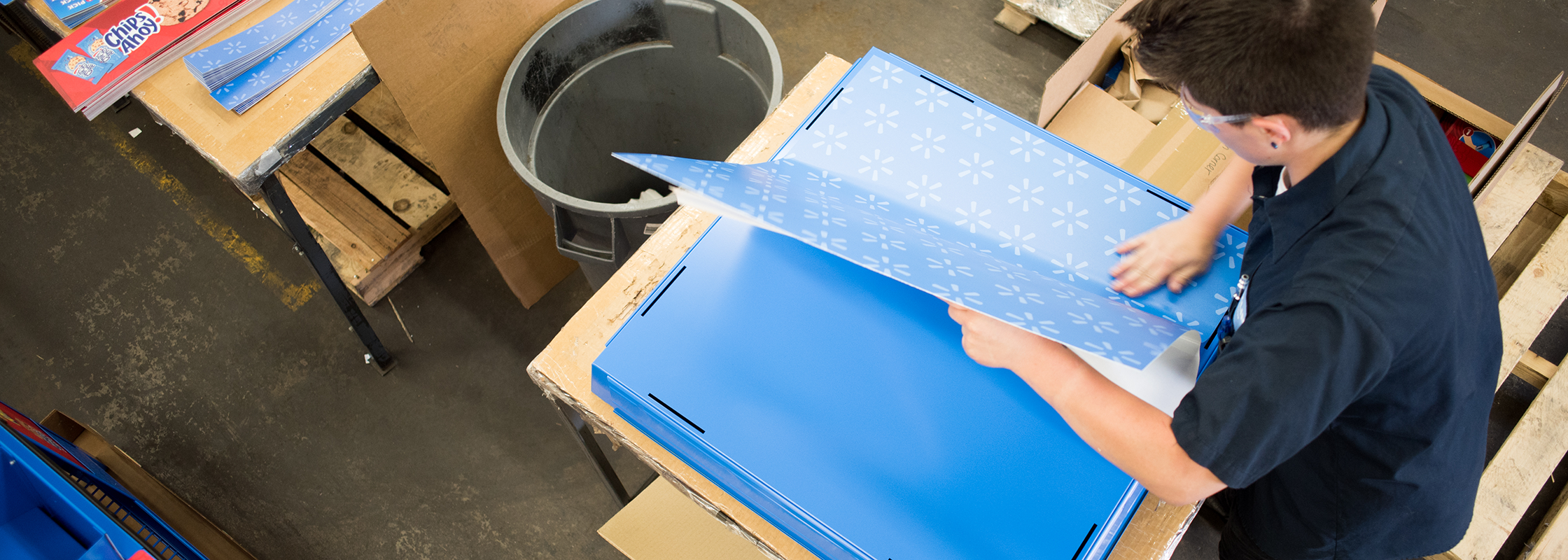 man putting a graphic on a box that has been powder coated